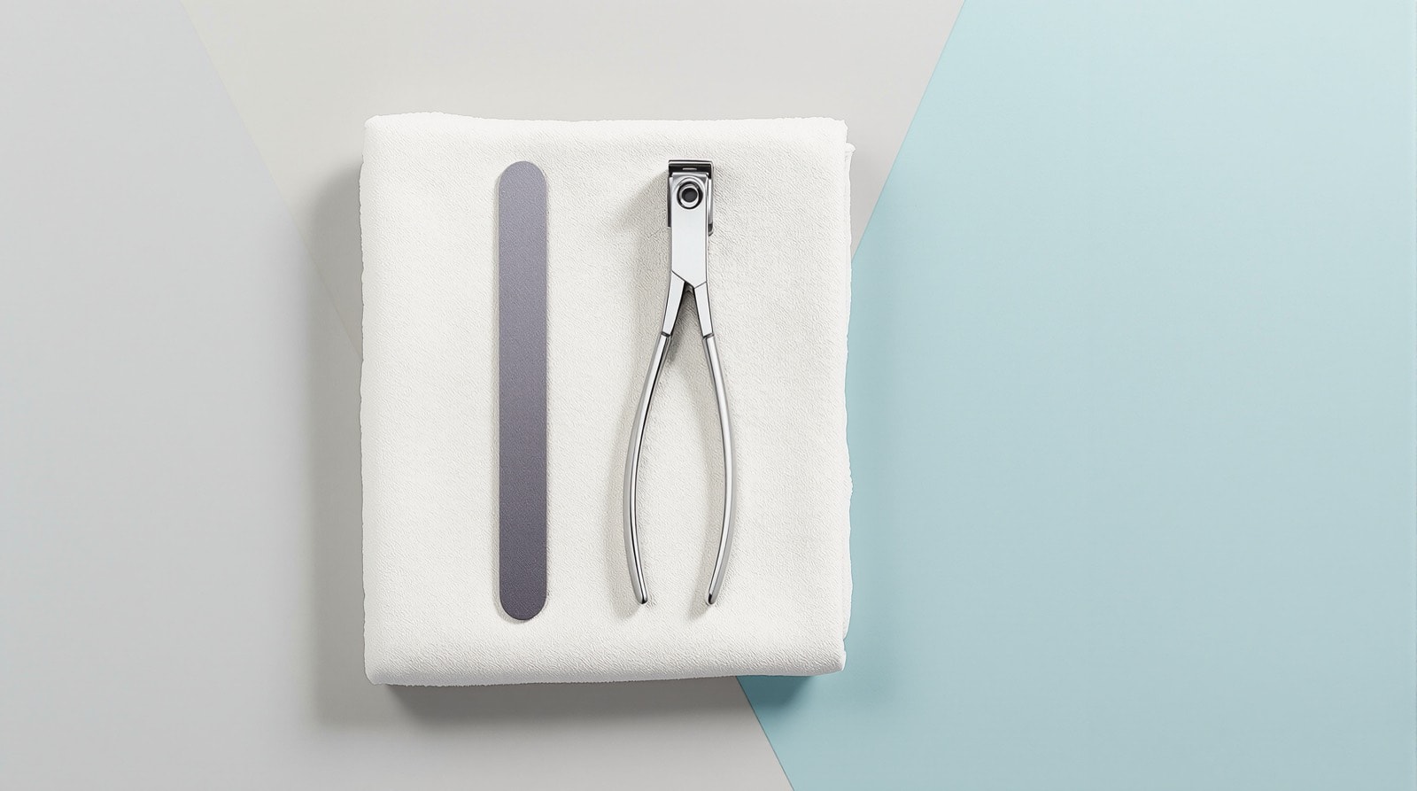 Nail clippers and a small file laid out on a clean pale cloth